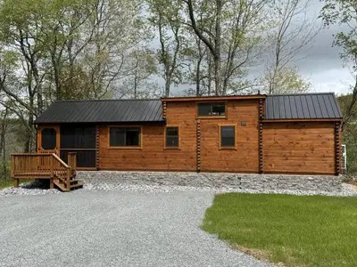 a log cabin with a black roof on a driveway at Tiny Cabin #3 by Windham NY Escape 'Forest View' in Hensonville