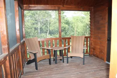 two chairs and a table on the porch of a cabin at Tiny Cabin #4 by Windham NY Escape 'Cabin Comfort' in Hensonville