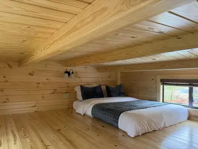 a bedroom with a bed in a wooden cabin at Tiny Cabin #5 by Windham NY Escape 'Scenic Stay' in Hensonville