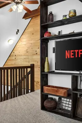 a living room with a tv on a shelf at Hideout Pocono Chalet in Lake Ariel