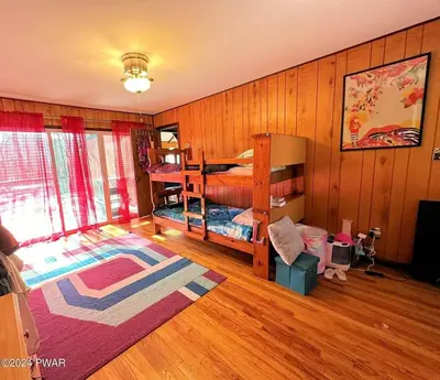 a bedroom with a bed and bunk beds in it at Paradise Uncovered Chalet Near Lake in Hawley