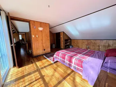 a bedroom with a bed and a wooden floor at Paradise Uncovered Chalet Near Lake in Hawley