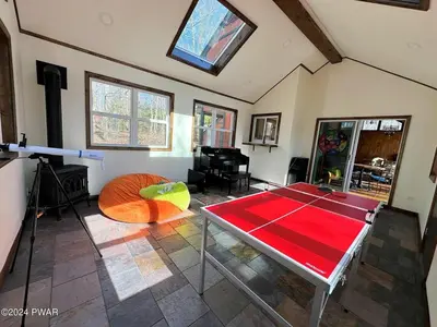 a living room with a ping pong table at Paradise Uncovered Chalet Near Lake in Hawley