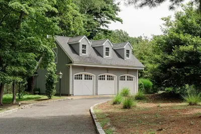 a house with a garage with a driveway at Waterfront Paradise in St James in Nissequogue
