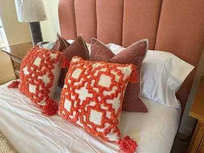 a bed with several pillows on it with a headboard at Waterfront Paradise in St James in Nissequogue