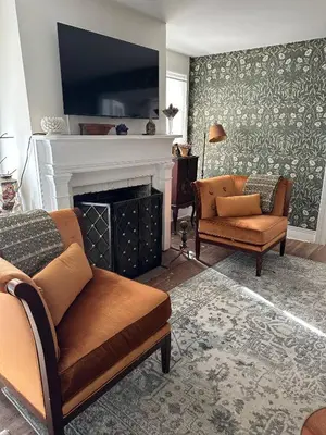 a living room with two chairs and a fireplace at Historic Home near Stony Brook Village & Beach in Stony Brook