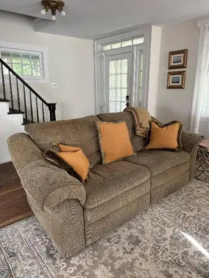 a brown couch with pillows in a living room at Historic Home near Stony Brook Village & Beach in Stony Brook