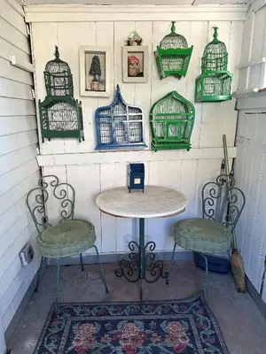 a room with two chairs and a table and birds cages at Historic Home near Stony Brook Village & Beach in Stony Brook