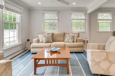 a living room with two couches and a coffee table at Pool, Sunroom and Gardens Luxe Sandy Hook Home!