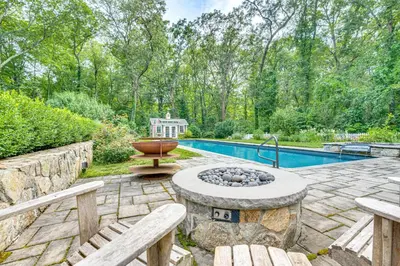 a backyard with a fire pit and a pool at Pool, Sunroom and Gardens Luxe Sandy Hook Home!