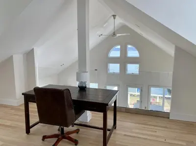 a desk with a chair in a room with a window at Waterfront Luxury in Town in Piermont