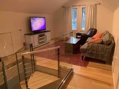 a living room with a television and a chair at Waterfront Luxury in Town in Piermont