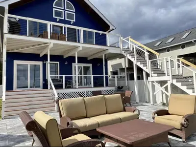 a house with a couch and chairs on a patio at Waterfront Luxury in Town in Piermont