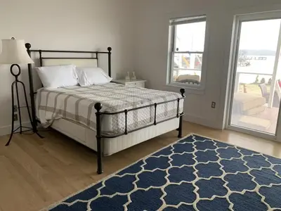a bedroom with a bed and a blue rug at Waterfront Luxury in Town in Piermont