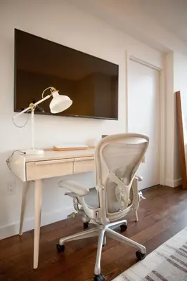 an office with a desk with a chair and a lamp at Modern Designer Stunning Hudson Views Corner Unit in New York
