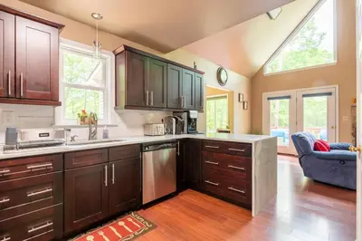 a large kitchen with wooden cabinets and a blue couch at Cozy 4-Season Chalet w Arcades & Lake, Ski Lifts in Lackawaxen