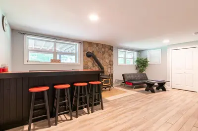 a living room with a bar and stools at Cozy 4-Season Chalet w Arcades & Lake, Ski Lifts in Lackawaxen