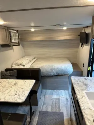a small room with two beds and a table at Cozy Camper Retreat on Sleepy Hollow Lake in Athens