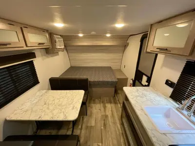 a small room with two beds and a sink at Cozy Camper Retreat on Sleepy Hollow Lake in Athens