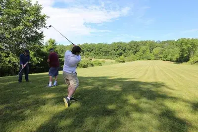 a group of people playing golf in a field at Cozy Camper Retreat on Sleepy Hollow Lake in Athens