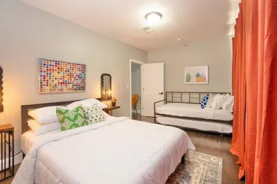 a bedroom with two beds and an orange curtain at Sky Walk at The Hillside in Newark