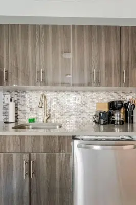 a kitchen with wooden cabinets and a sink and a dishwasher at Modern House in Black Rock in Bridgeport