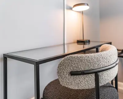 a glass desk with a chair and a lamp at Cozy Modern Apt Close to NYC NO STEPS or Stairs in South Hackensack