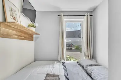 a small room with a bed and a window at Cozy Modern Apt Close to NYC NO STEPS or Stairs in South Hackensack