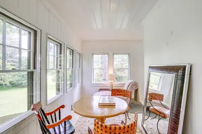 a room with a table and chairs and windows at Steps to Downtown Stockbridge Home with Patio! in Stockbridge