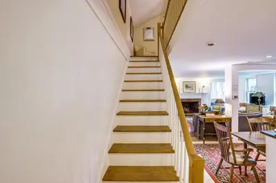 a staircase in a home with white walls and wooden floors at Steps to Downtown Stockbridge Home with Patio! in Stockbridge