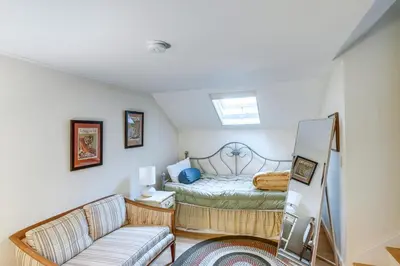 a small bedroom with a bed and a couch at Steps to Downtown Stockbridge Home with Patio! in Stockbridge