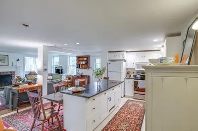 a kitchen with white cabinets and a table and chairs at Steps to Downtown Stockbridge Home with Patio! in Stockbridge