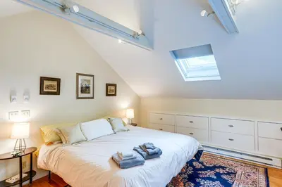 a bedroom with a large bed with towels on it at Steps to Downtown Stockbridge Home with Patio! in Stockbridge