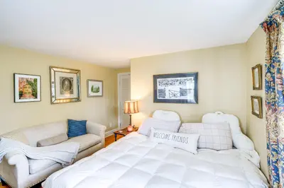 a bedroom with a white bed and a couch at 2 Mi to Norman Rockwell Museum Stockbridge Apt! in Stockbridge