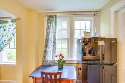 a kitchen with a table and a refrigerator and a window at 2 Mi to Norman Rockwell Museum Stockbridge Apt! in Stockbridge