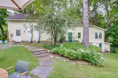 a yard with a house with a tree and two chairs at 2 Mi to Norman Rockwell Museum Stockbridge Apt! in Stockbridge