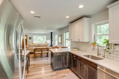 a kitchen with white cabinets and a dining room at Family Home with Outdoor Oasis in Hudson Valley in High Falls