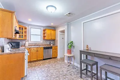 a kitchen with wooden cabinets and a counter top at 6Br 2bth NYC Penn Station NYC USA Mall EWR in Newark