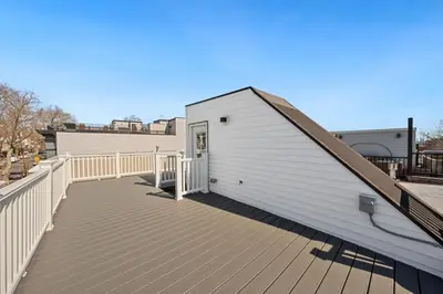 a large white building with a wooden deck at NYC Skyline Views • Near Times Sq • Rooftop Deck in Jersey City