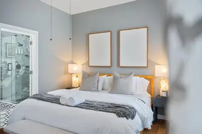a bedroom with a large white bed with two mirrors at NYC Skyline Views • Near Times Sq • Rooftop Deck in Jersey City