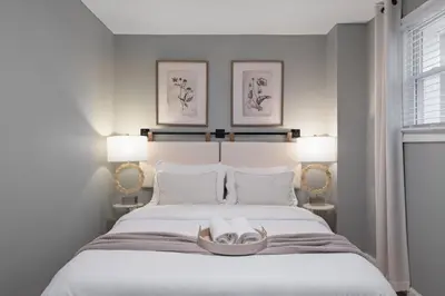 a bedroom with a large white bed with two lamps at Modern Condo with Private Porch, Mins to NYC in Jersey City