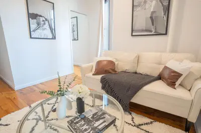 a living room with a dog laying on a couch at Chic 2BD Upper East Side Retreat in New York