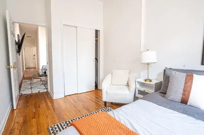 a bedroom with a bed and a chair in a room at Chic 2BD Upper East Side Retreat in New York