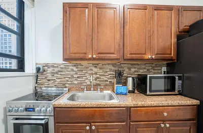 a kitchen with a sink and a microwave at Chic 2BD Upper East Side Retreat in New York