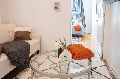 a living room with a glass table and a couch at Chic 2BD Upper East Side Retreat in New York