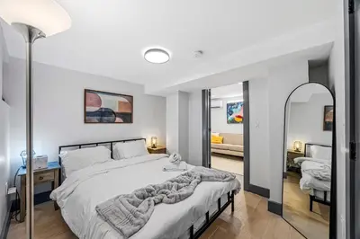 a bedroom with a large bed and a mirror at luxury 2 bed 2 bath apt with free parking in Jersey City