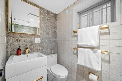 a bathroom with a toilet and a sink and a mirror at luxury 2 bed 2 bath apt with free parking in Jersey City