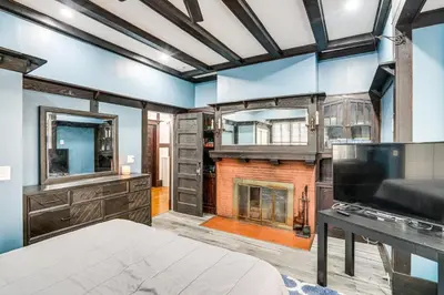 a bedroom with a fireplace and blue walls at Steps to Union College Home with Shared Yard! in Schenectady