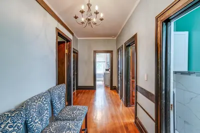 a living room with a blue couch and a chandelier at Steps to Union College Home with Shared Yard! in Schenectady