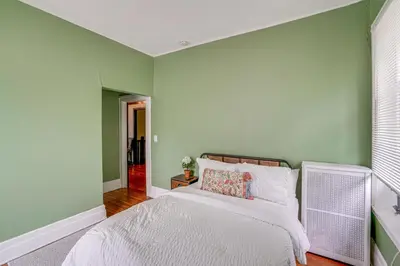 a bedroom with green walls and a white bed at Steps to Union College Home with Shared Yard! in Schenectady